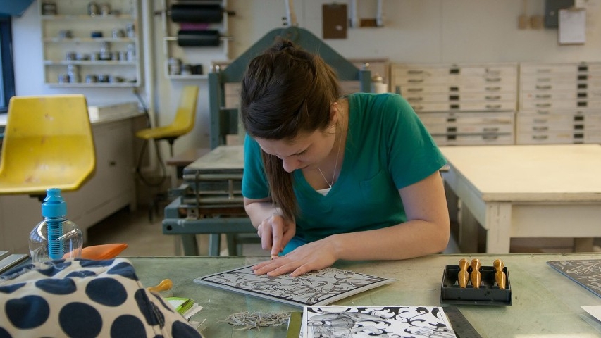 Student cutting heavy paper