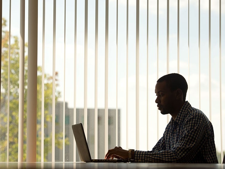 Silhouette of law student at laptop working in an office