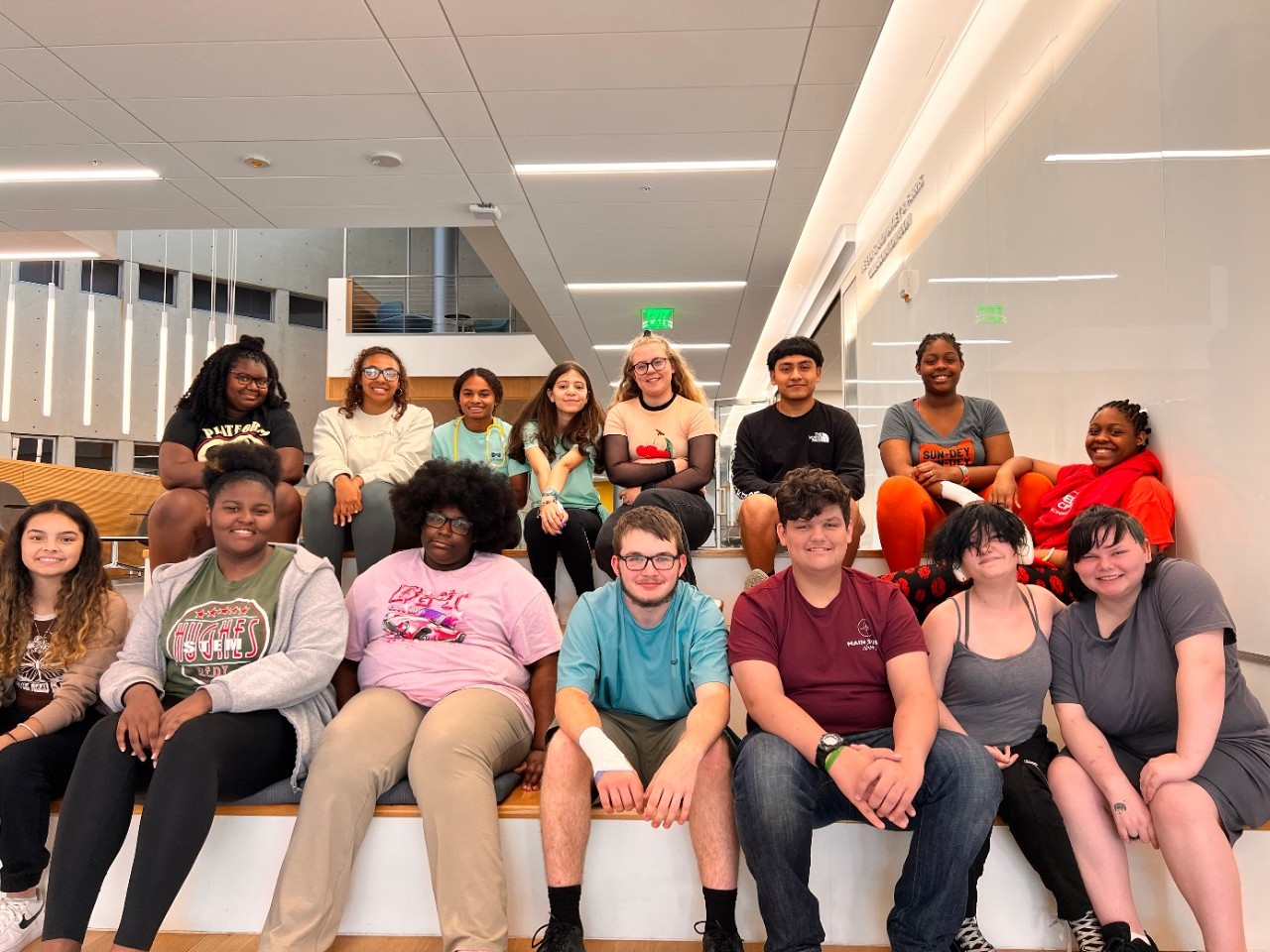 Group of middle school students posing on a tiered seating area. 