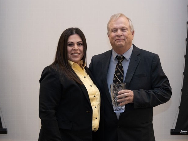 Daryl Landrum holding award with Christina Roybal